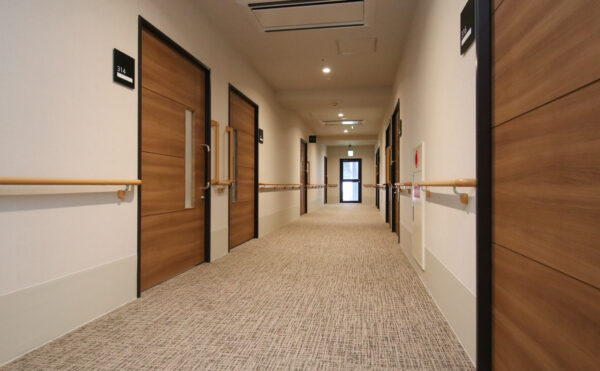 廊下　広い廊下はカーペット仕上げで両側手すり配置で安心して移動出来ます。　（リヤンドファミーユ）