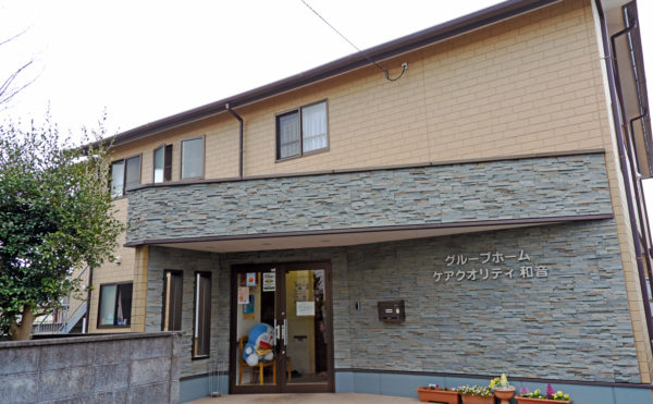 静岡市葵区のグループホーム ケアクオリティ和音の外観写真　石調の外壁のエントランス存在感のある施設で訪れる人を迎え入れます。