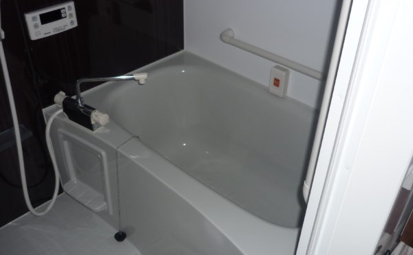居室の浴室　清潔感のあるシンプルな内装の居室に設置された浴室で手すりを適所に配置しています。（ココファミリア沼津）
